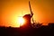 Beautiful view of a silhouette of a windmill in the field at golden hour
