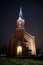 Beautiful view of small lovely local church in late evening with iluminated lights