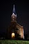 Beautiful view of small lovely local church in late evening with iluminated lights