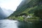 Beautiful view of a small village on the lakeside with green mountains. Naeroyfjord, Norway.