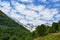 A beautiful view of the snow-capped mountain peaks of the Caucasus Mountains. White clouds against the blue blue sky