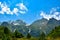 A beautiful view of the snow-capped mountain peaks of the Caucasus Mountains. White clouds against the blue blue sky