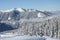 Beautiful view of the snow-covered spruces, mountains and low clouds in winter