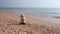 Beautiful view of stone cairn on coast with oncoming wave.