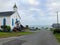 A beautiful view of a street with a Church and the vast Pacific Ocean in the background,