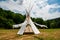 Beautiful view of the summer wedding tipi in a field. Tee pee built on green grass. Traditional teepee tent wigwam located in