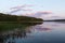 Beautiful view of sunset on a lake with symmetrical reflections in the water of pink clouds