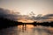 Beautiful view of sunset and river on which pair of people swim on the sup boards