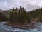 Beautiful view of Sunwapta River in autumn season with trees on little island surrounded by coniferous forest in autumn.