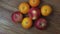 Beautiful view of three red apples and orange mandarins rotating on wooden background