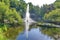 A beautiful view of a transparent fountain of beating in a pond amidst beautiful nature on a hot summer day.