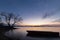 Beautiful view of Trasimeno lake Umbria at dusk, with a little boat silhouette in the foreground, perfectly still