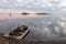 Beautiful view of Trasimeno lake Umbria at dusk, with a little, old boat partially filled by water, perfectly still