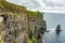 Beautiful view of a vertical wall of the Cliffs of Moher and the Branaunmore sea stack