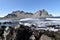 Beautiful view of the Vestrahorn Mountains with black sand and the ocean in front near Hoefn in Iceland