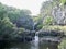 Beautiful view of a waterfall pouring in the middle of mountainous scenery in Hawaii