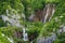 Beautiful view of waterfalls with turquoise water and wooden pathway through over water. Plitvice Lakes National Park, Croatia. Fa