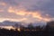 Beautiful view of the winter sunset with silhouettes of forest trees and an old church against the sky