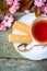 Beautiful, vintage teacup with Japanese cherry tree blossom and Scottish shortbread, close up