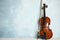 Beautiful violin and bow on wooden table near light blue wall. Space for text