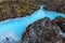 Beautiful volcanic terrain with black volcanic rocks and turquoise water at blue lagoon geothermal spa in Iceland