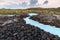 Beautiful volcanic terrain with black volcanic rocks and turquoise water at blue lagoon geothermal spa in Iceland