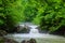 Beautiful wallpaper milk waterfall flow rapid stream. Caucasus rocky mountain river in forest. Isichenko waterfall, Guamka, Mezmay