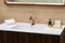 A beautiful washbasin with a copper tap and fittings. Marble sink, square led mirror, wooden cabinet