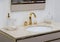 A beautiful washbasin with a gold tap and fittings. Marble sink, round led mirror