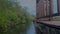 Beautiful water ripples on lake with mangroves and wooden rail of footbridge. Peaceful nature background. Film grain