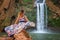 Beautiful waterfall in Morocco. Back of woman in beautiful dress looking fall Ouzoud. Exotic nature of North Africa,