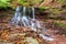 Beautiful waterfall in a mountain stream in the forest. One of the waterfalls of the cascade of Rusiliv waterfalls. Rusyliv,