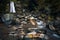 Beautiful waterfall in the mountains flowing through some stones during autumn