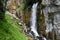 Beautiful waterfall rushing down a cliff and bursting onto a steep rocky mountainside