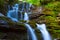 Beautiful waterfall rushing in mountain canyon