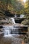 Beautiful waterfalls from above the hills with the background of fall foliage near Buttermilk Falls, Ithaca, New York