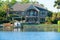 Beautiful waterfront house with artistic stone work with FOR SALE sign in yard
