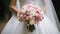 Beautiful wedding bouquet in hands of the bride. Bouquet of rose flowers, close up