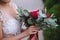 Beautiful wedding bouquet in hands of the bride. Gold ring and white dress