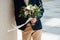 Beautiful wedding bouquet in hands of the groom