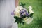 Beautiful wedding bouquet of milk gerberas and lilac irises in the bride`s hand