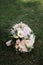 beautiful wedding bouquet of white flowers lies on the grass