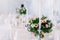 Beautiful wedding floral decoration on a table in a restaurant. White tablecloths, bright room, candles, close-up shooting. The ev