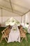 Beautiful wedding floristics on wooden tables in a spacious white tent