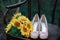 Beautiful wedding shoes with high heels and a bouquet of sunflowers on a vintage chair