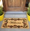 Beautiful welcome peach color coir doormat with flower border Placed outside door with green leaves