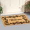 Beautiful welcome peach color coir doormat with flower border Placed outside door with green leaves