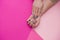 Beautiful well-groomed women`s hands with an interesting manicure on a pink background. A place for text