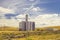Beautiful wheat field landscape and a big silo barrel towers on