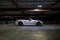 Beautiful white Aston Martin Vanquish parked alone in an empty, dimly lit parking garage